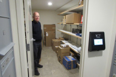 Man Holding Open Door of Package Room