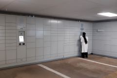 Woman Retrieving Packages from Parking Garage Locker Installation Woman Retrieving Packages from Parking Garage Locker Installation