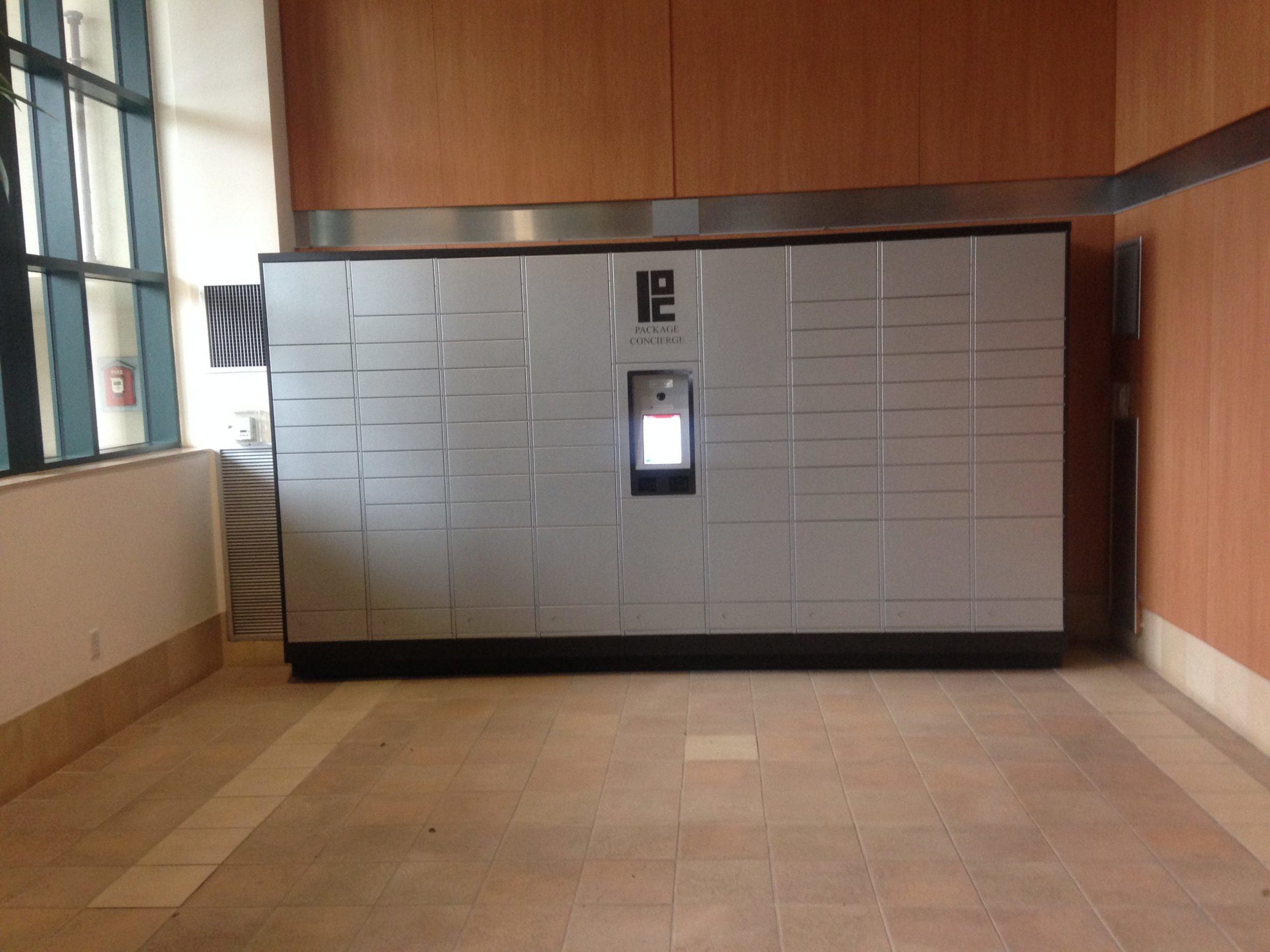 A Package Concierge® automated smart package locker system installed at Cambridge Oxford in gray with black trim