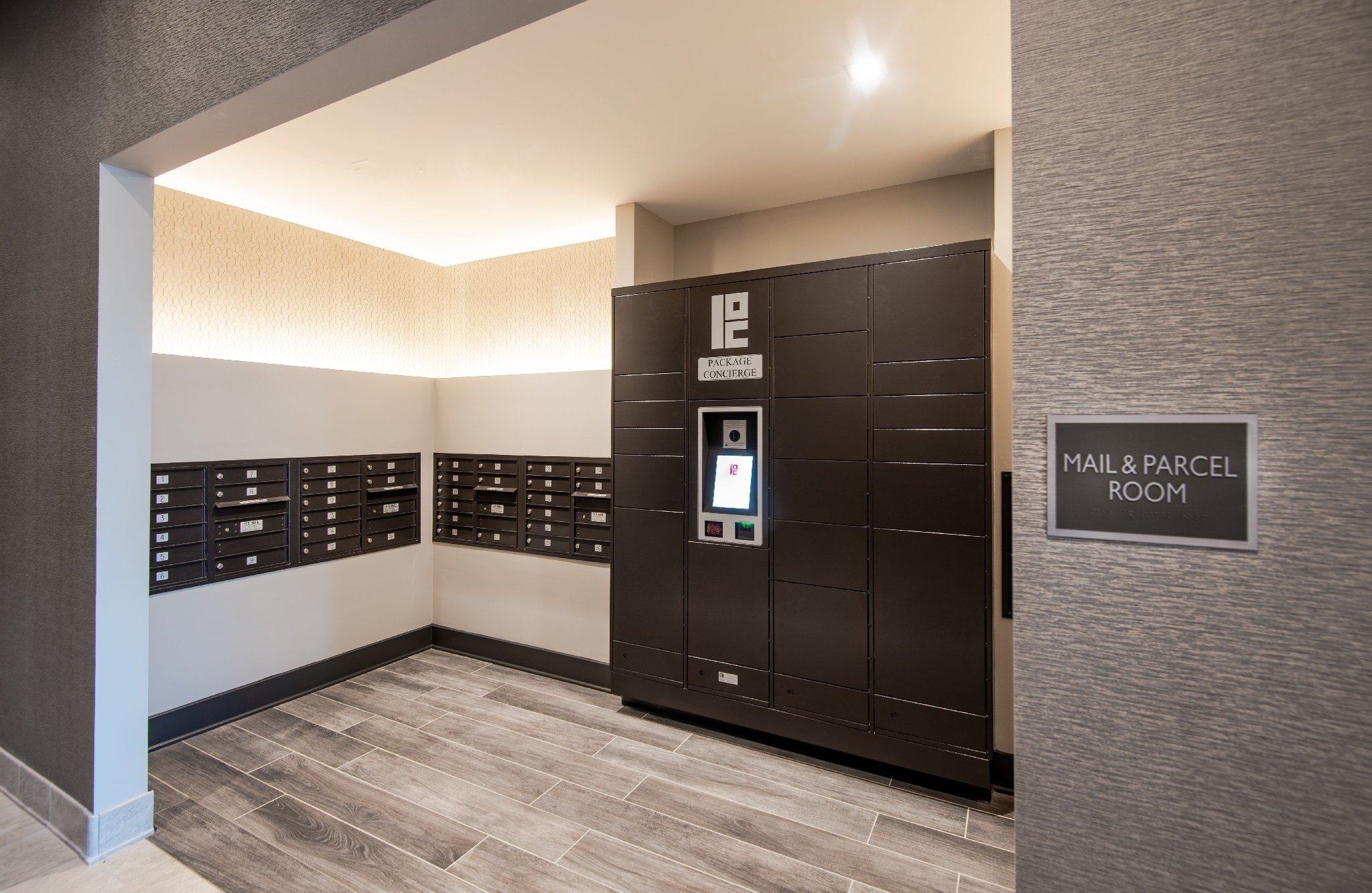 A mail & parcel room with an electronic parcel locker system in black and gray from Package Concierge®