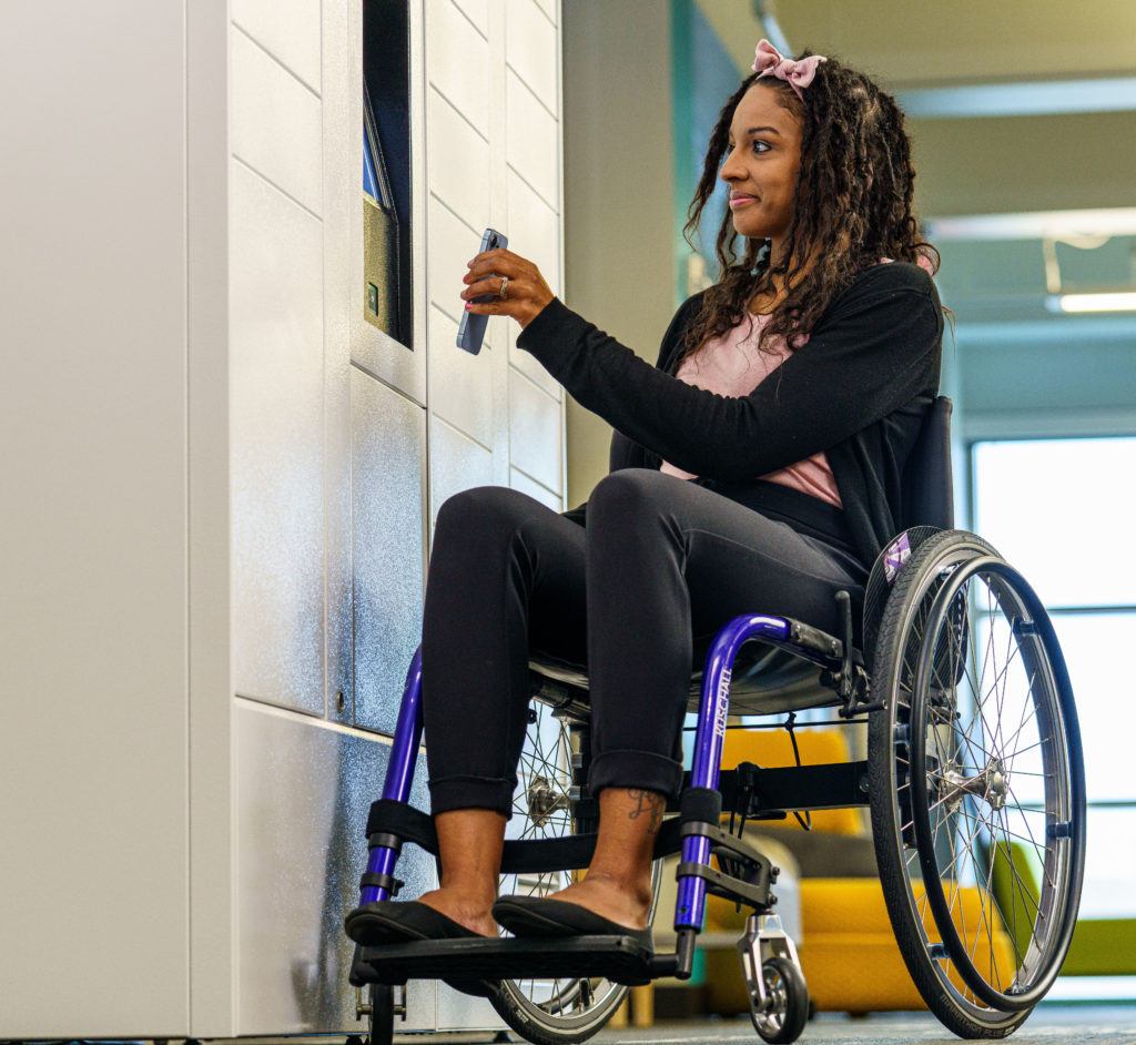 Woman sitting in wheelchair using locker system